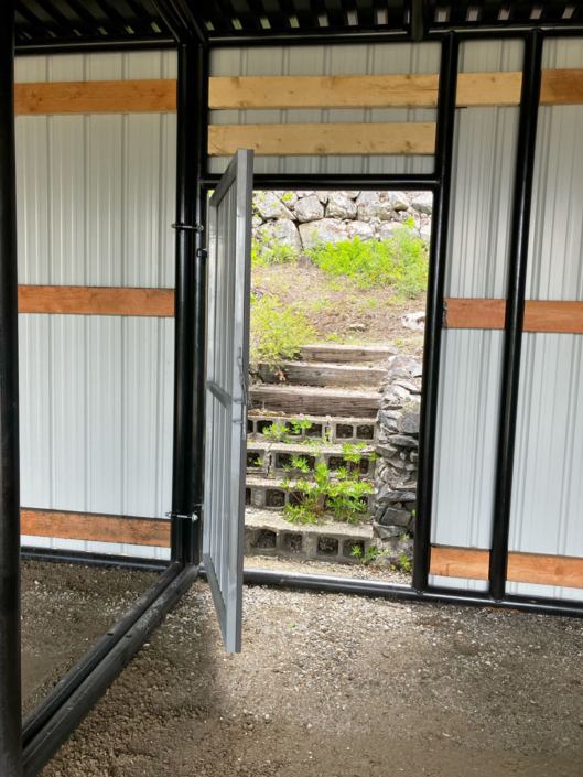 Access door located in the back of a custom residential 3-bay parking structure built in Revelstoke, BC